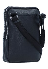 Bolsa de ombro em couro preto com uma superfície texturizada, fecho de correr prateado e uma alça de tecido ajustável para usar cruzada. Forma compacta e retangular.