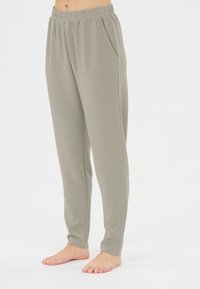 Ljusgrå, mjuka joggers i tyg med elastisk midja, sidofickor och en tapered design. Lämpliga för vardagsklädsel eller som hemmakläder.