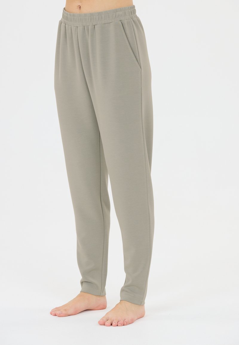 Ljusgrå, mjuka joggers i tyg med elastisk midja, sidofickor och en tapered design. Lämpliga för vardagsklädsel eller som hemmakläder.