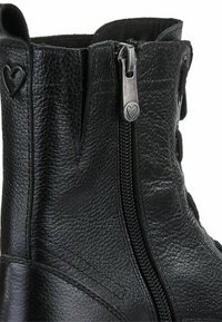Black leather ankle boot featuring a side zipper, heart-shaped accents, textured surface, and a structured design.