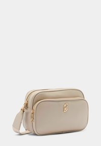 Borsa a tracolla beige realizzata in materiale sintetico liscio, con due scomparti con zip e dettagli in metallo color oro.