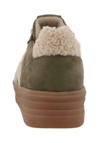 Grüne Wildleder-Sneaker mit einem flauschigen cremefarbenen Kragen, ausgestattet mit einer Gummisohle und strukturierten Details entlang der Ferse. Minimalistisches Design.