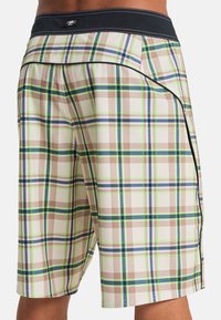 Καρό μαγιό σορτς με βάση σε αποχρώσεις του καφέ και πράσινες, μπλε και καφέ λεπτομέρειες. Ελαστική μέση με μαύρη επένδυση, ορατές πλαϊνές τσέπες.