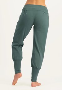 Türkise, kurze Jogginghosen aus weichem Material mit einem breiten Bund, Falten am Rücken und elastischen Bündchen an den Knöcheln.