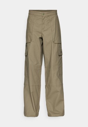 Cargo pants in olive green fabric, featuring a loose fit, multiple side pockets, and a button closure at the waist. Smooth texture.