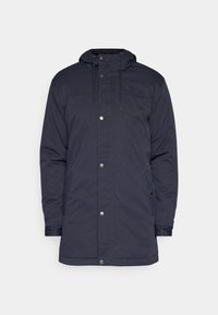 Tumma laivastonsininen hupullinen parkatakki, jossa edessä painonapit, kiristysnauhallinen huppu, pitkät hihat ja sivutaskut.