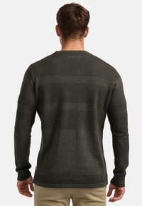 Maglione verde scuro con un motivo testurizzato, caratterizzato da strisce orizzontali di diversi stili di lavorazione sul retro e polsini a coste.