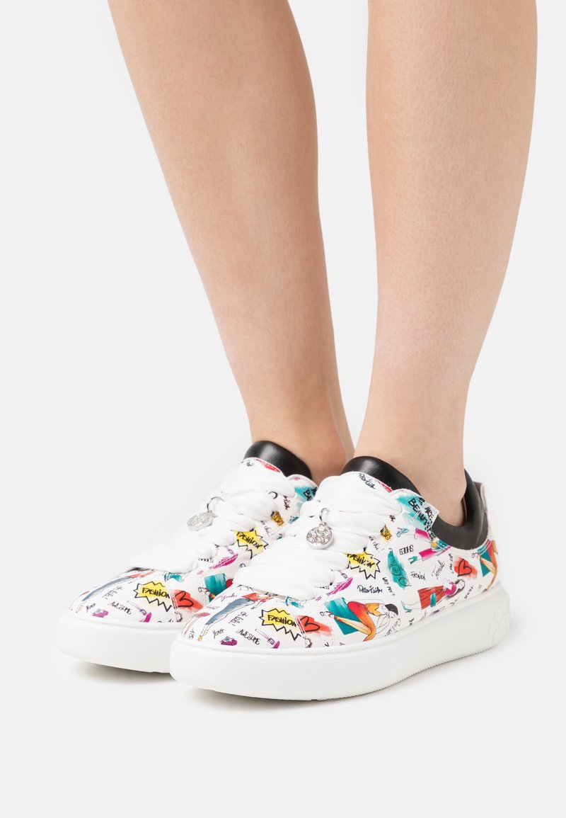 Las zapatillas blancas cuentan con gráficos coloridos con varios diseños; detalles negros en el talón y una suela de goma texturizada.