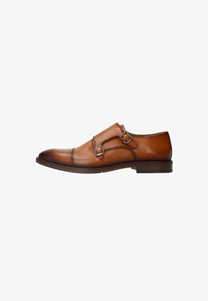 Bruine leren jurk schoenen met dubbele monk strap ontwerp, ronde neus, contrasterende stiksels en een strakke, glanzende afwerking. Platte rubberen zool.