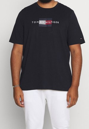 T-shirt nera in cotone con maniche corte, caratterizzata da un logo a strisce orizzontali in rosso, bianco e blu. Design con scollo a girocollo.