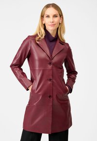Burgundy leather trench coat with a notched collar, front buttons, and side pockets, featuring a smooth texture and tailored fit.