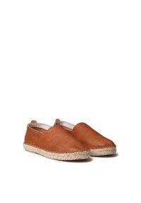 Zapatos de cuero marrón tipo slip-on con punta redondeada y suela de yute estilo espadrille. Textura suave con costuras mínimas y un diseño sencillo.