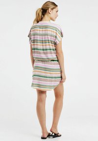 Vestido rayado con mangas cortas y onduladas, de corte relajado y dobladillo asimétrico. Los colores incluyen rosa, verde, amarillo y blanco.