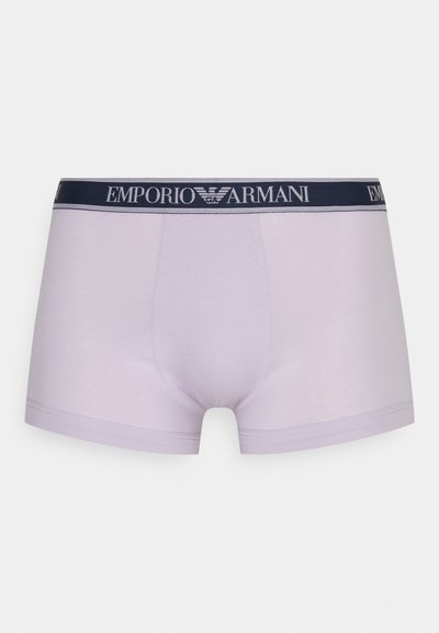 Lila boxer alsónemű sima anyagból, tengerészkék rugalmas derékpánttal, melyen fehérrel van nyomtatva az "EMPORIO ARMANI" logó.