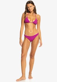 Ribbed bikini set in magenta with a triangle bralette and low-rise bottoms. Features thin straps and a smooth texture.