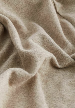 Light brown, soft fabric with a smooth, slightly textured surface, showcasing subtle folds and waves. Ideal for clothing or upholstery.