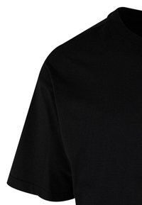 Camiseta de manga corta negra, hecha de algodón, con un escote redondo y textura suave y uniforme, con un ajuste clásico. Sin patrones ni elementos metálicos visibles.