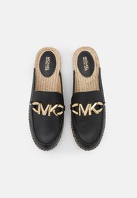Scarpe slip-on in pelle nera con dettaglio in oro del logo MK, soletta in juta intrecciata e trama liscia. Presentano una punta arrotondata e cuciture a contrasto.