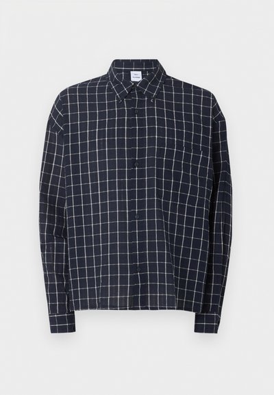 Πουκάμισο σε ναυτικό μπλε με λευκό σχέδιο πλέγματος, μακριά μανίκια, τσέπη στο στήθος και μύτη γιακά.