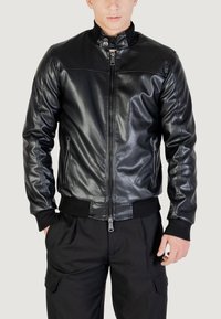 Černá kožená bomber bunda s vysokým límcem, zipovým zapínáním a žebrovanými manžetami. Hladký povrch, dvě zipové kapsy po stranách.