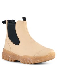 Beige Chelsea-boots med svart elastisk sidopanel, gummibaserad sula och strukturerad sula för grepp. Har en dragflik vid hälen för enkel påtagning.