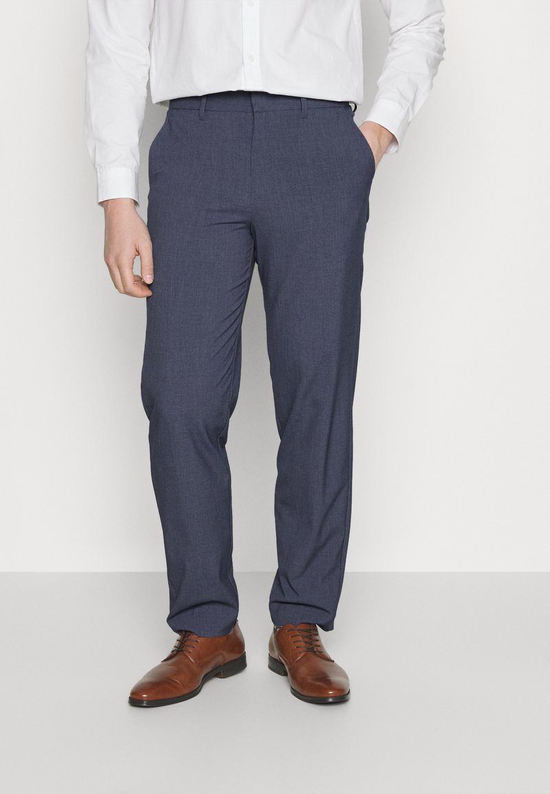 Blue tailored trousers with a smooth texture, featuring a flat front and side pockets, paired with brown leather dress shoes.