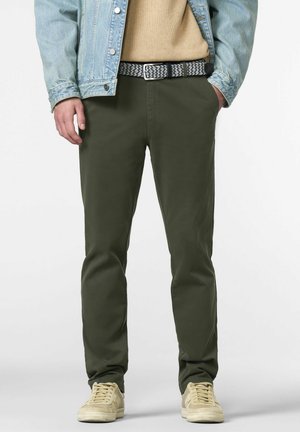 Chinos olive en coupe ajustée, avec une taille plate et des poches latérales, associés à des baskets beiges et une ceinture tissée à motifs.