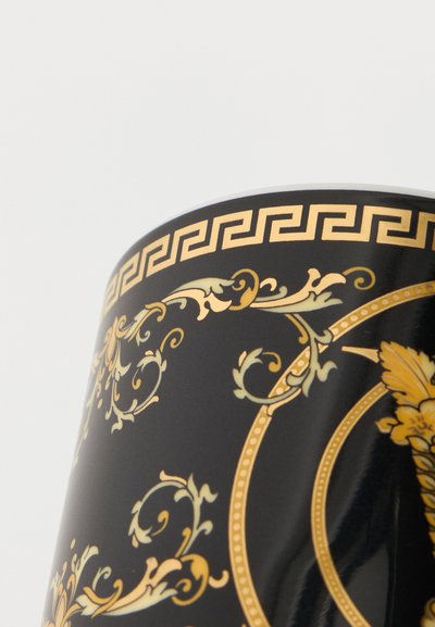 Μαύρο κεραμικό φλιτζάνι με περίπλοκα χρυσά μπαρόκ λουλουδένια σχέδια και περίγραμμα με ελληνικό κλειδί κοντά στην άκρη σε λευκό φόντο.