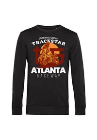 Svart sweatshirt med långa ärmar som har en grafisk design av en motorcykelåkare mot en orange cirkel, med texten "International Trackstar Atlanta Raceway".