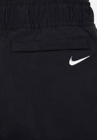 Juodi sportiniai šortai, pagaminti iš lengvos medžiagos, su elastinga juosmens juosta ir mažuoju baltu Nike logotipu šone.
