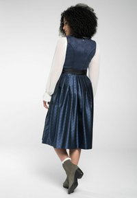 Navy blue dress with a fitted bodice, pleated skirt, and contrasting black waistline. Sheer long sleeves with textured fabric.
