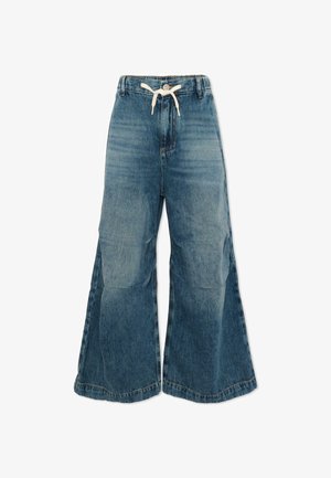 Pantalon en denim bleu à jambes larges avec une taille haute, fermeture à boutons et cordon de serrage blanc à la taille.
