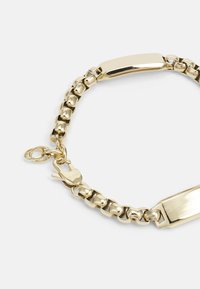 Bracciale dal tono dorato con design a catena, centro rettangolare piatto e chiusura a gancio. Texture liscia in tutto il bracciale.