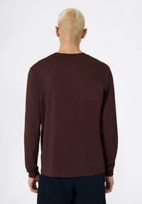Chemise à manches longues en tissu marron foncé avec un col rond, présentant des manches ajustées et un ourlet droit, vue de dos.