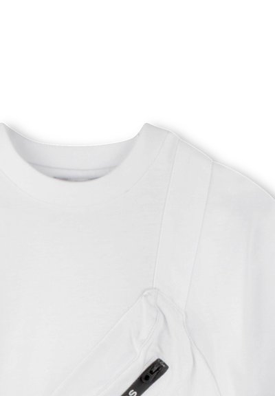 Witte katoenen t-shirt met een opvallende diagonale zak met een zwarte rits. Soepele textuur met een ronde hals en korte mouwen.