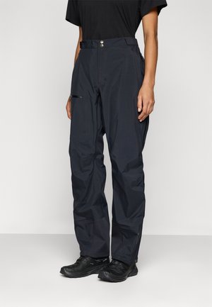 Black waterproof pants, loose fit with a smooth texture. Features a zipper pocket on the thigh and two metallic buttons at the waist.