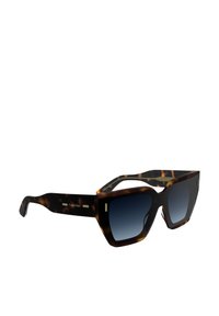 Gafas de sol carey con montura angular sobredimensionada, lentes oscuros en degradado y acentos dorados en las patillas. Diseño clásico con un toque moderno.