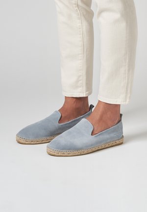 Espadrilles en daim bleu clair avec un bout fermé et des côtés élastiques, dotées d'une semelle en corde de jute et de détails de couture le long du bord.