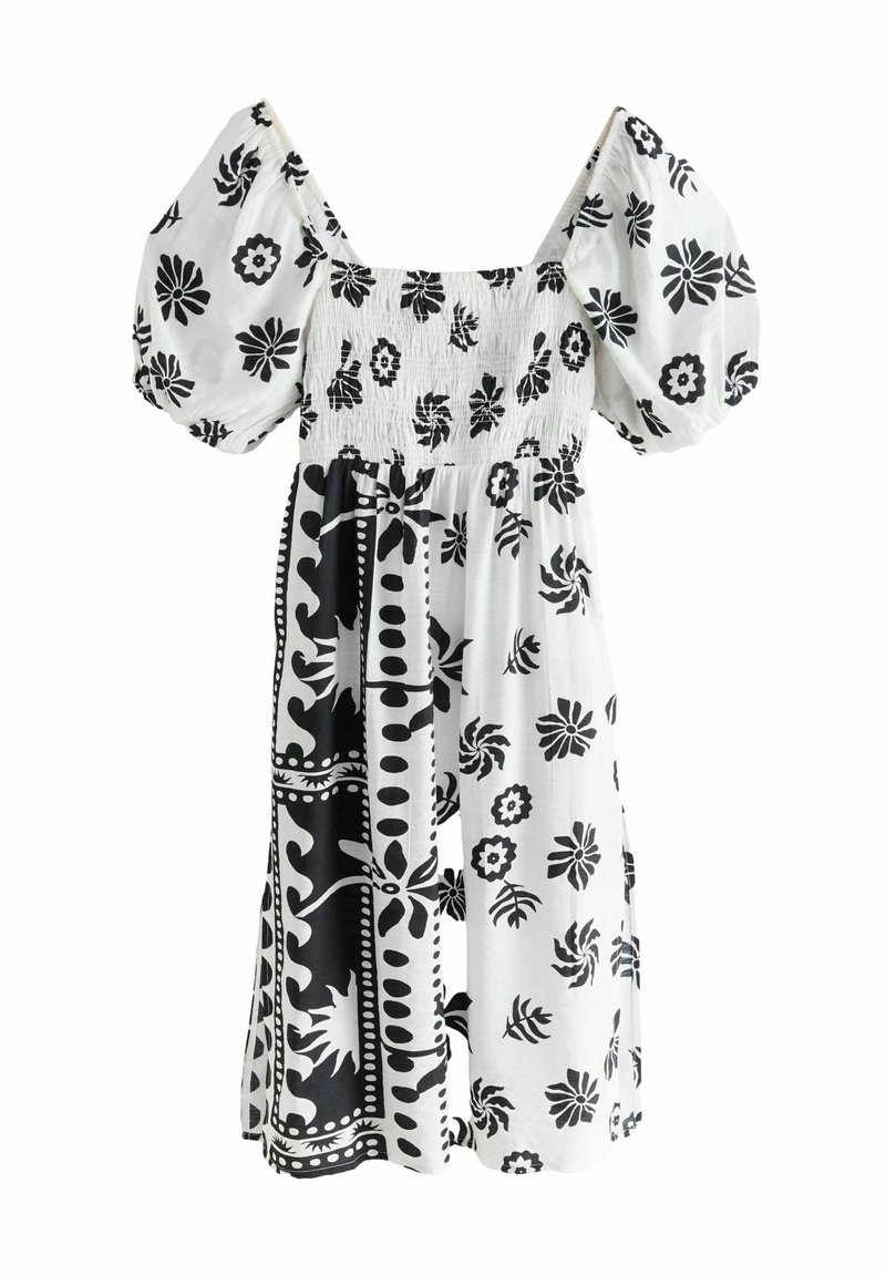 Svart och vit blommig klänning med puffärmar, smockad bodice, knälång silhuett och kontrasterande mönster på kjoldelen.
