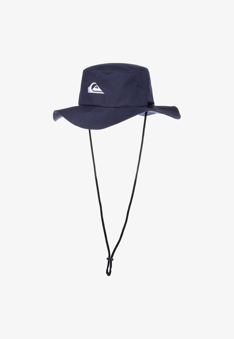 Modrá mäkká čiapka vyrobená z textilu, s širokým brímom, nastaviteľným krčným pásom a bielou nášivkou s logom na prednej strane.