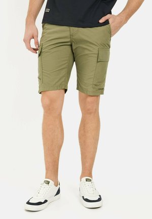 Olivenfarvede cargo shorts lavet af letvægtsstof, med to sidelommer og en let afslappet pasform. Kombineret med hvide sneakers.