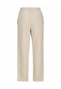 Pantalones de chándal beige fabricados con un material suave, con un corte relajado, cintura elástica, bolsillos laterales y diseño de pierna recta.