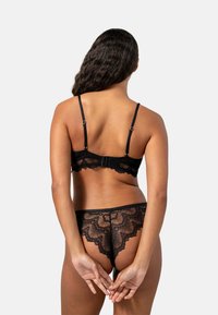 Svart spetsbehå och matchande trosor, med scalloped kanter och blommönster. Justerbara band och krokstängning på behån.