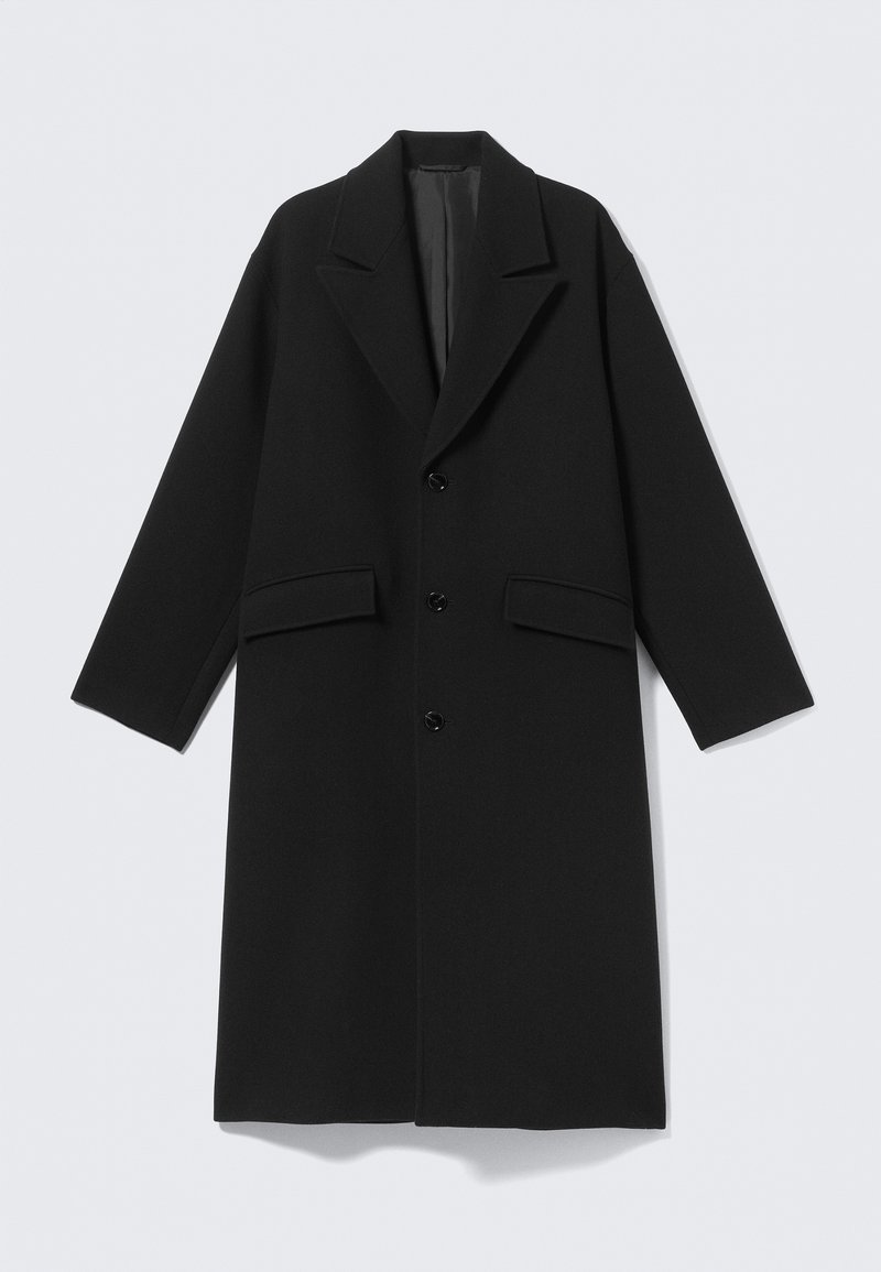 Manteau long en laine noire avec revers crantés, trois boutons sur le devant et deux poches à rabat, présenté à plat sur un fond clair.