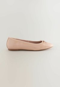 Nude Ballerinas aus glänzendem Lackleder, mit einer abgerundeten Spitze und einer kleinen Schleifen-Applikation an der Vorderseite, sowie einer flachen Gummisohle.