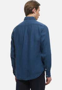 Camicia a maniche lunghe blu navy in tessuto leggero, con colletto button-down e orlo arrotondato. Presenta una texture sottile e polsini con un bottone.