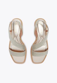 Tan sandals with light grey braided straps and a metallic gold insole. Square toe and flat sole design. Soft texture and minimal detailing.
