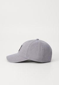Graue Stoff-Baseballkappe mit gebogenem Schirm, gestickten Ösen und einem kleinen Logo auf dem Vorderteil. Strukturierter, strapazierfähiger Stoff.