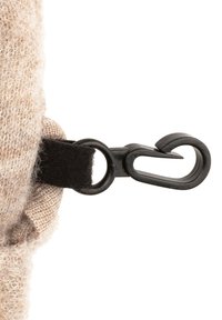 Beiger Stoff mit einer flauschigen Textur, ausgestattet mit einem schwarzen Klettverschlussriemen und einem schwarzen Kunststoff-Hakenverschluss. Nahaufnahme der Befestigungsdetails.