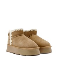 Tawny suède enkellaarsjes met een zachte witte voering, voorzien van een gekartelde rand en een dikke beige platformzool met een gestructureerde loopvlak.